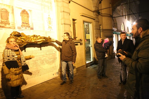 사람들이 행운의 상징, 에베라르트 동상을 만지고 있다.